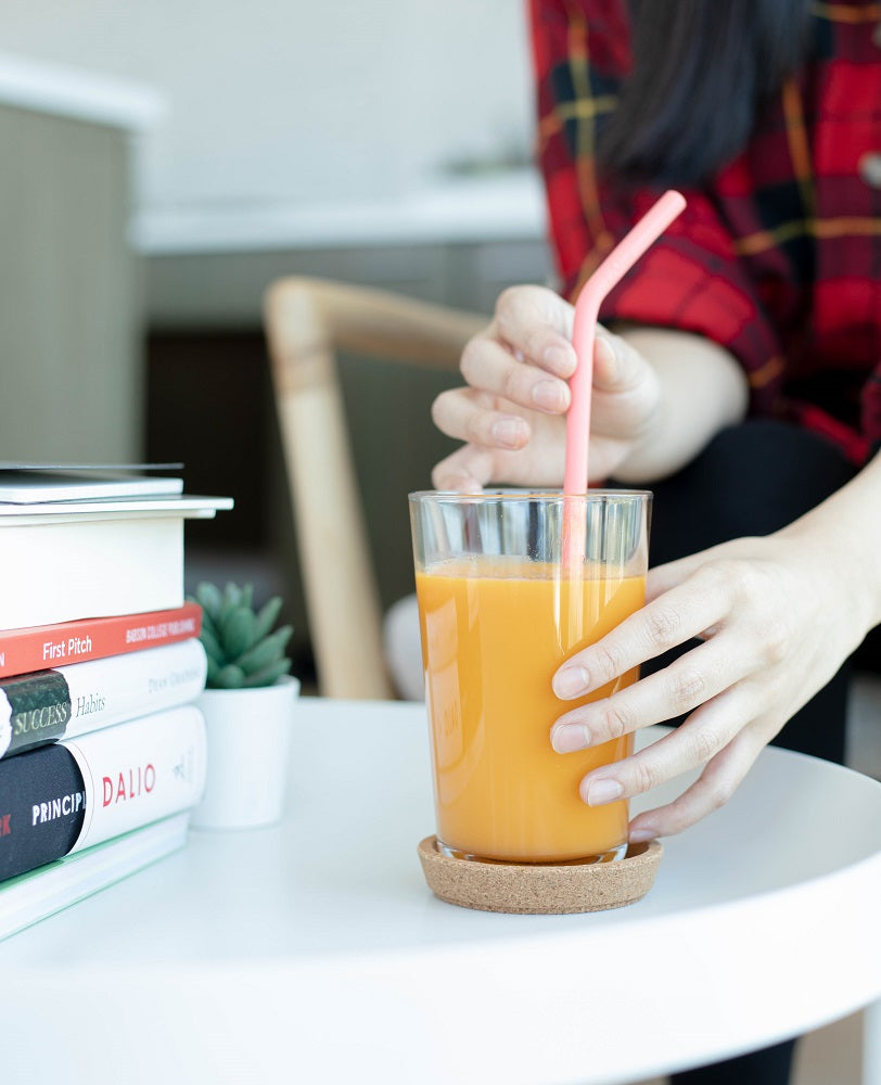 Living Coral Silicone Straw in a glass of orange juice