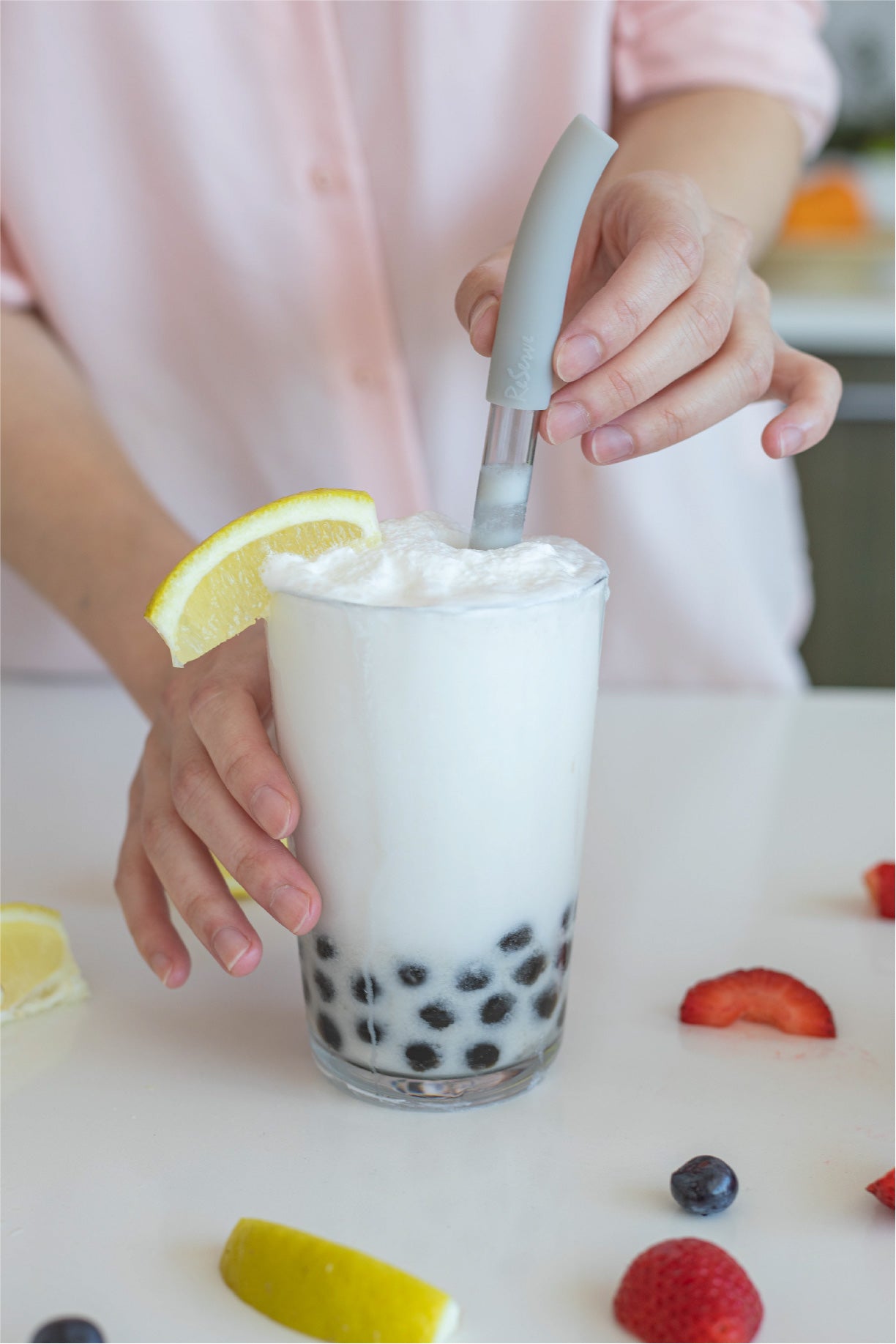 Silver bubble tea straw in a glass of coconut smoothie with pearl