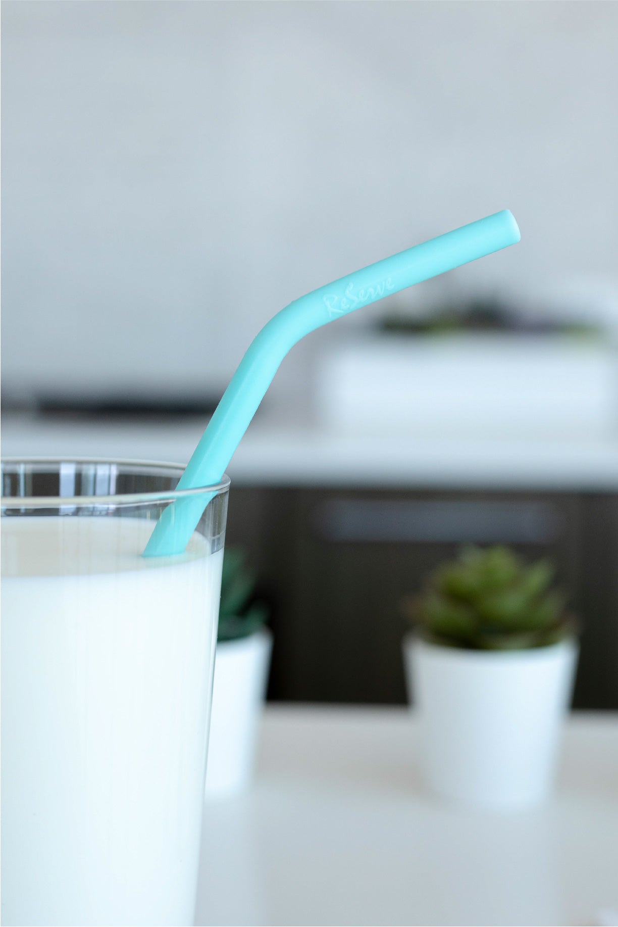Blue Island Paradise Silicone Straw closed up in a glass of milk