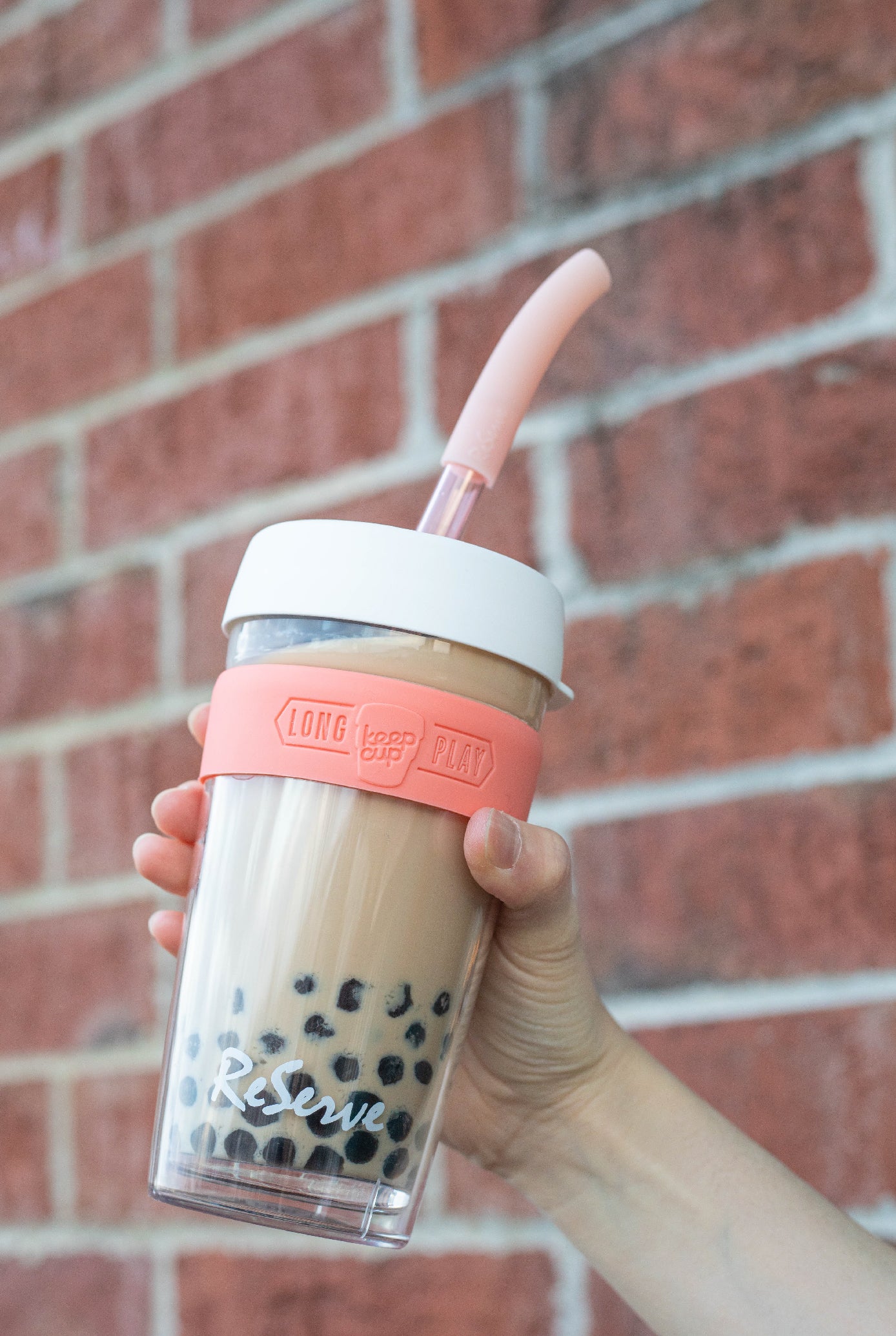 Rose gold bubble tea straw in a ReServe KeepCup of milk tea with boba/pearl
