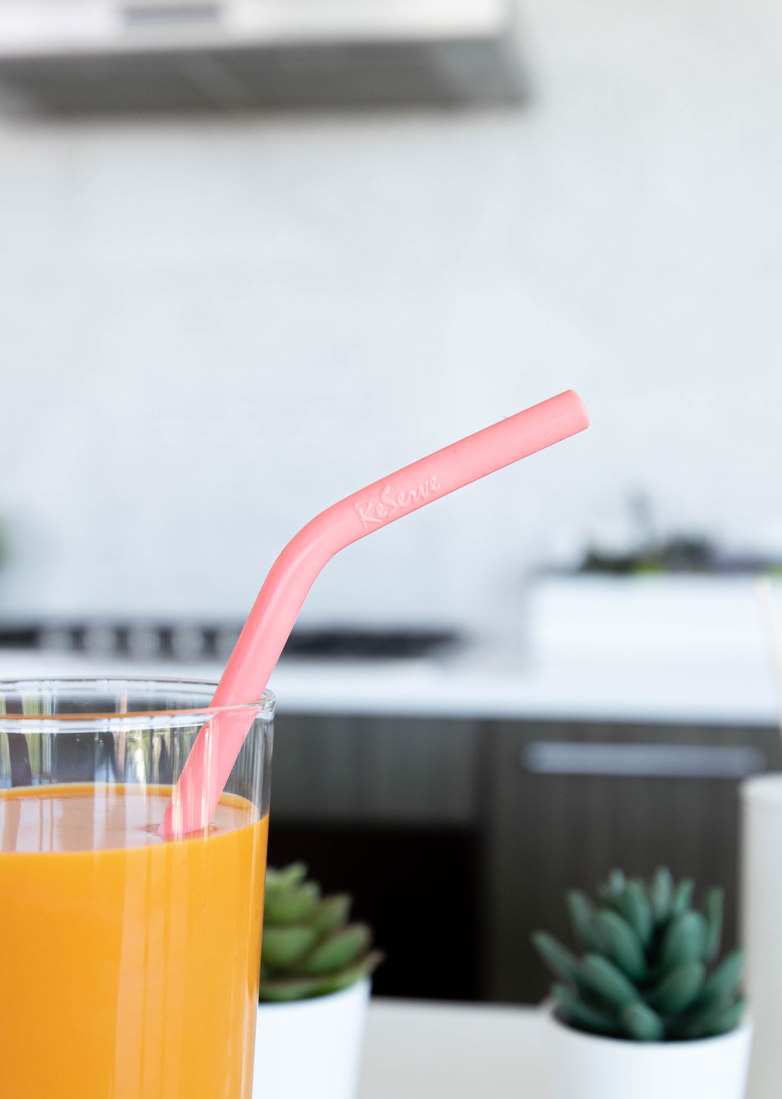 Close up of Living Coral Pink Silicon Drinking Straw in the glass of milk